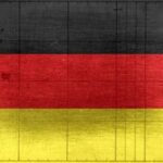 Grungy background designed as flag of Germany on shabby wooden board with measure scale